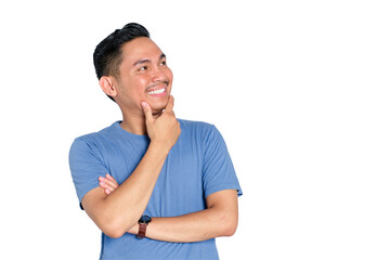 Smiling young Asian man touching chin while looking up with thoughtful expression, decision making,...