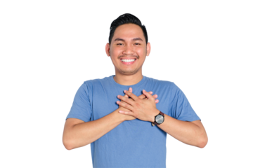 Smiling young Asian man expressing gratitude with hands on chest, thankful and sincere gesture, isolated on transparent background
