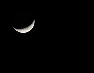 夜空に輝くシャープな三日月と深い闇のコントラスト