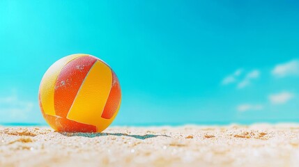 Obraz premium A vibrant beach ball resting on sandy beach under a bright sunny sky.