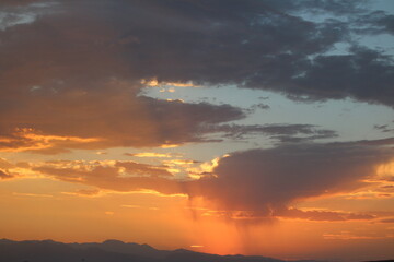 Fototapeta premium Beautiful Sunsets in the Desert Sky as Clouds Look Like Rain