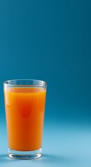 A refreshing glass of vibrant orange juice, perfect for a sunny morning, against a bold blue background.