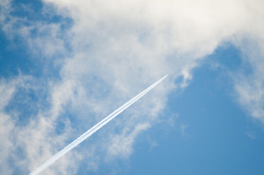 In the photo there is a line of an airplane in the blue sky