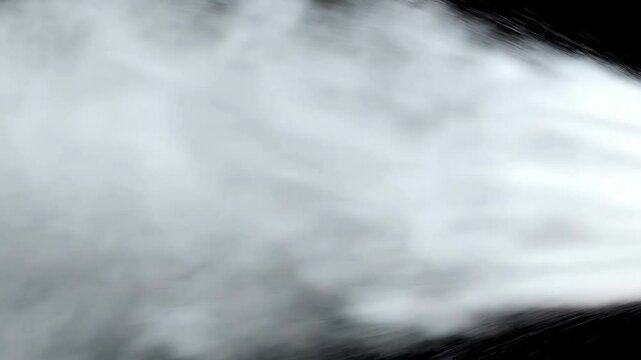Close-up of fire extinguisher nozzle releasing cloud of white foam. Camera rapidly zooms in, capturing dynamic movement of foam and its rapid expansion