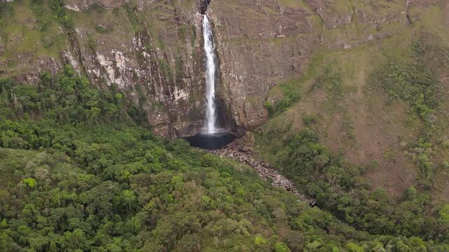 Tall waterfall flowing into a natural pool in Serra da Canastra, Brazil, aerial view