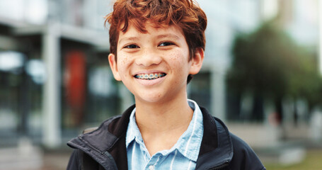 Outdoor, school and boy with smile in portrait, education and studying opportunity with happiness. Campus, male child and student with with confidence for elementary, learning academy and braces