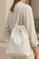 Minimalist White Drawstring Bag Worn by Woman in Neutral Outfit