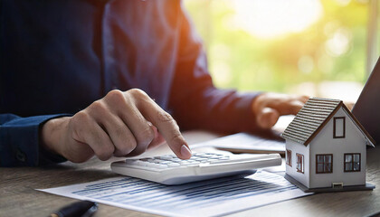 Young man pressing calculator to check and calculate home loan cost for refinancing plan. Concept of buying and selling home and real estate price.