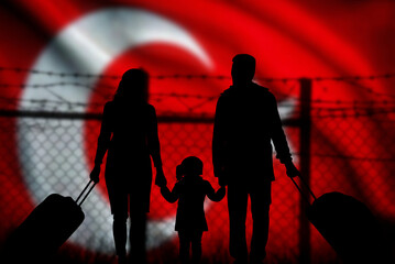 A family stands in front of the barbed wire at the Turkish border