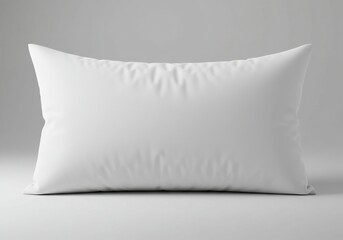 A single white rectangular pillow resting on a white surface against a gray background studio shot