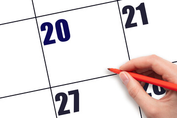 Calendar date 20. A hand holding a red pen is about to write text on an empty white calendar page...