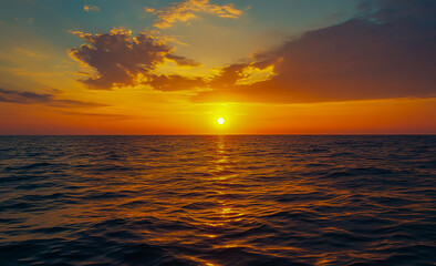 Fototapeta premium A mesmerizing sunset over the calm sea, the golden sun sinking far below the horizon, vibrant colors splashing across the sky.