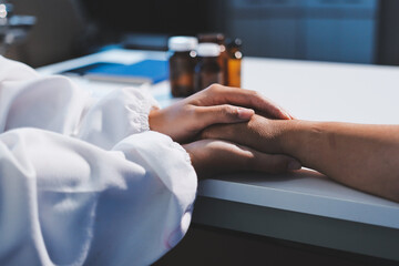 Closeup, doctor holding hands with senior woman and cancer care or support. Healthcare or trust,...