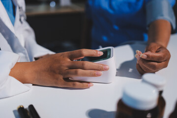 Doctor using sphygmomanometer with stethoscope checking blood pressure to a patient in the hospital.