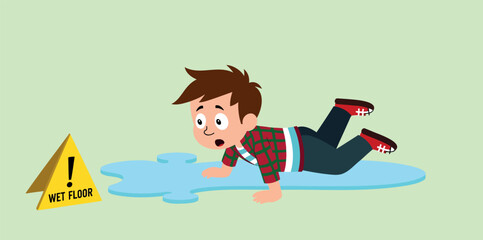 surprised boy lies on a wet floor near a yellow wet floor sign