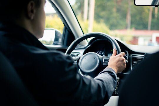 Driver in rideshare car or taxi. Test drive or training. Used vehicle insurance. Delivery man or ride share business. Illegal cab. Behind view.