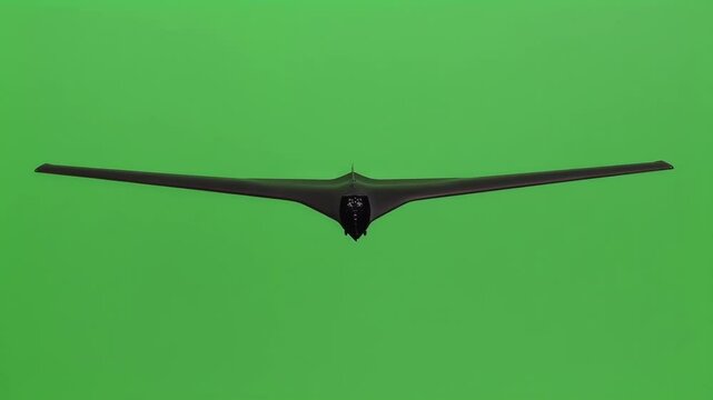 Military aircraft, a stealth bomber, is flying straight towards the viewer against a vibrant green screen background, ideal for chroma key compositing and video editing