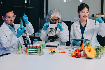 Team Asian scientists in a lab conducting food research using a microscope and lab equipment,...
