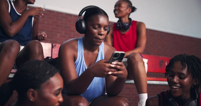 Headphones, sports and woman on bleachers with phone for listening to music, audio and radio. Basketball, team and person on smartphone online to relax after training, exercise and fitness in court