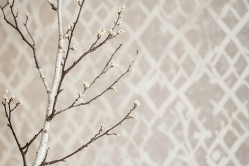 Naklejka premium Delicate branch with small white buds against a beige, patterned background.