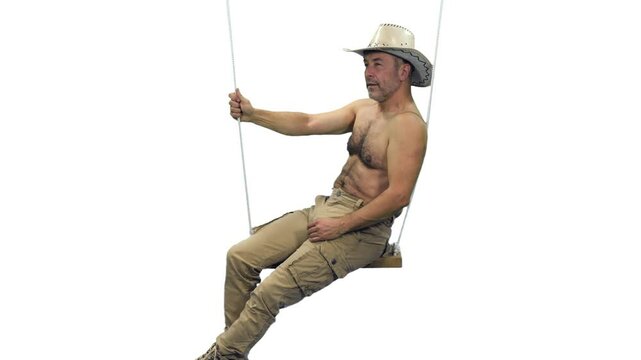 A middle aged shirtless man in cowboy hat relaxing on rope swing, Full HD footage with alpha transparency channel isolated on white background  