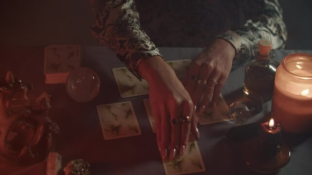 Fortune telling on tarot cards by candlelight, the fortune teller analyzes cards