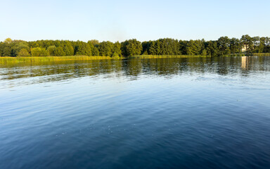 A calm lake with trees in the background