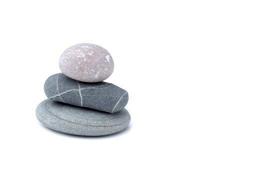 Against a white background stands a tower made of turned sea stones.