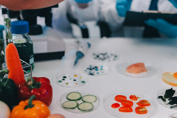 Team Asian scientists in a lab conducting food research using a microscope and lab equipment,...