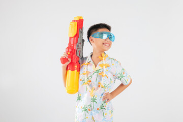 Songkran festival happiness as a smiling child boy plays with a water gun
