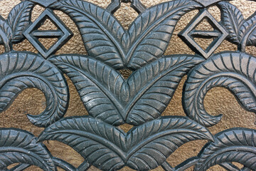 A close-up shot of an ornate metal casting with intricate leaf and geometric patterns, showcasing the beauty of decorative metalwork. The patterns, with their detailed leaf motifs