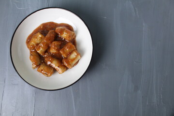 Meat dish, sausages, sausages in sauce on a gray background with space for text, copyspace, top view, top view