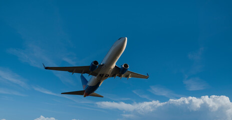 Passenger plane flying in the blue sky. Travelling by air transport