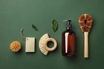 Dispenser and eco friendly cleaning brushes for washing dishes on green background. Flat lay eco cleaning products. Cleaner concept. Top view.