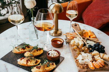 A table served for a dinner with different kinds of appetizers and wine in a bar or restaurant.