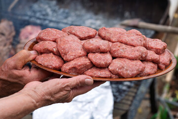 Man Grilling Juicy Meat Patties on Charcoal BBQ: Traditional Outdoor Cooking with Flames, Smoke, and Delicious Meat, Perfect for Gourmet Cuisine, Summer Picnics, Family Gatherings, and Celebrations.