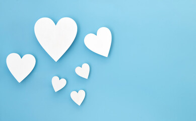 Wooden hearts on a baby blue background with copy space.