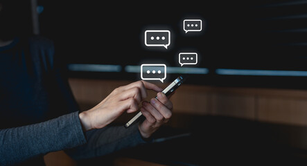 A person using a smartphone to send messages, with chat bubbles indicating ongoing conversations in a dark, modern environment.