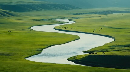 A river curving through a green valley, with grazing animals along the water's edge
