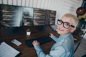 Young casual female coder working on digital solutions with confidence