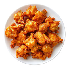 A top view of a white plate filled with golden brown crispy pakoras or fritters on a black background