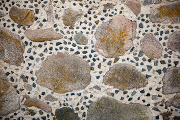 Weathered stone wall revealing traditional russian masonry, large rocks nestled among smaller stone...
