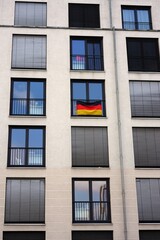 facade of a building. German flag on apartment balcony
Modern apartment building with symmetrical windows and minimalist architecture. 