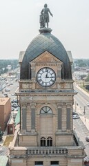 Historic clock tower with statue in small town
