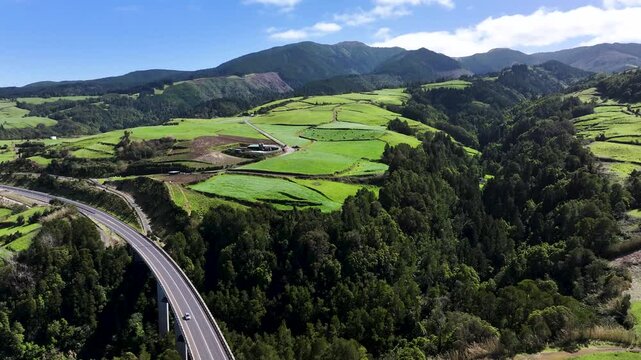 Car drives on Euroscut Highway bridge over ravine in Nordeste landscape, aerial