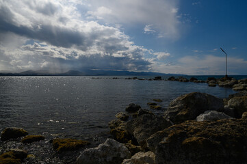 Breathtaking shoreline landscape at dusk with dramatic clouds and shimmering water reflections