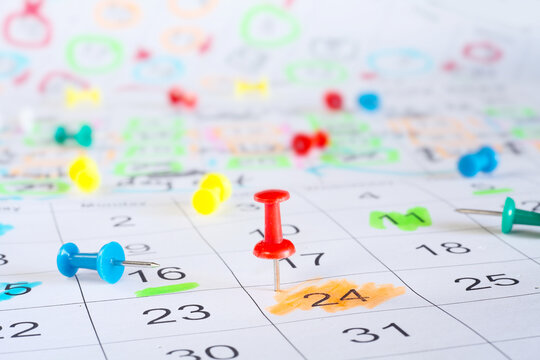 Calendar with business appointments and pushpins or thumbtacks, selective focus. Business concept,beat the clock,overworked, red tape.