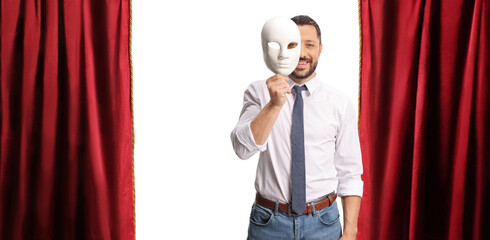 Man holding a white masquerade mask on stage