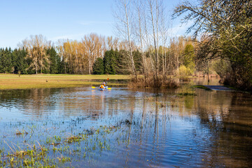 People kayaking in flooded park in spring