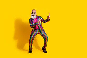 Full size photo of extravagant funny man direct finger phone empty space wear shiny costume isolated on yellow color background
